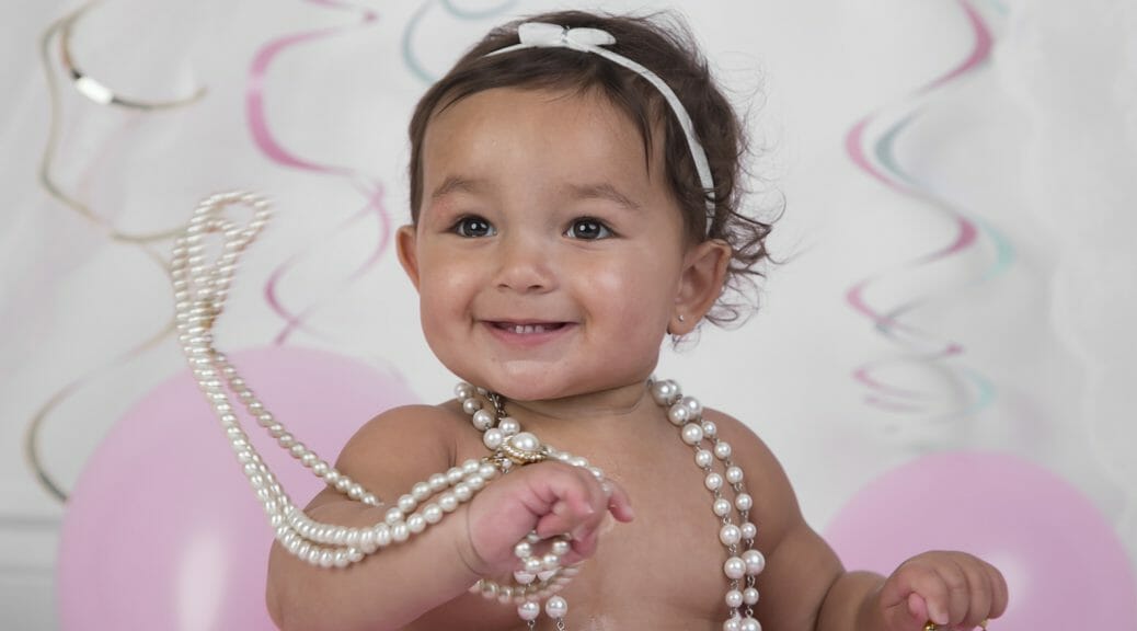 Baby Girl at her first birthday with steamers and pretty headband and tutu