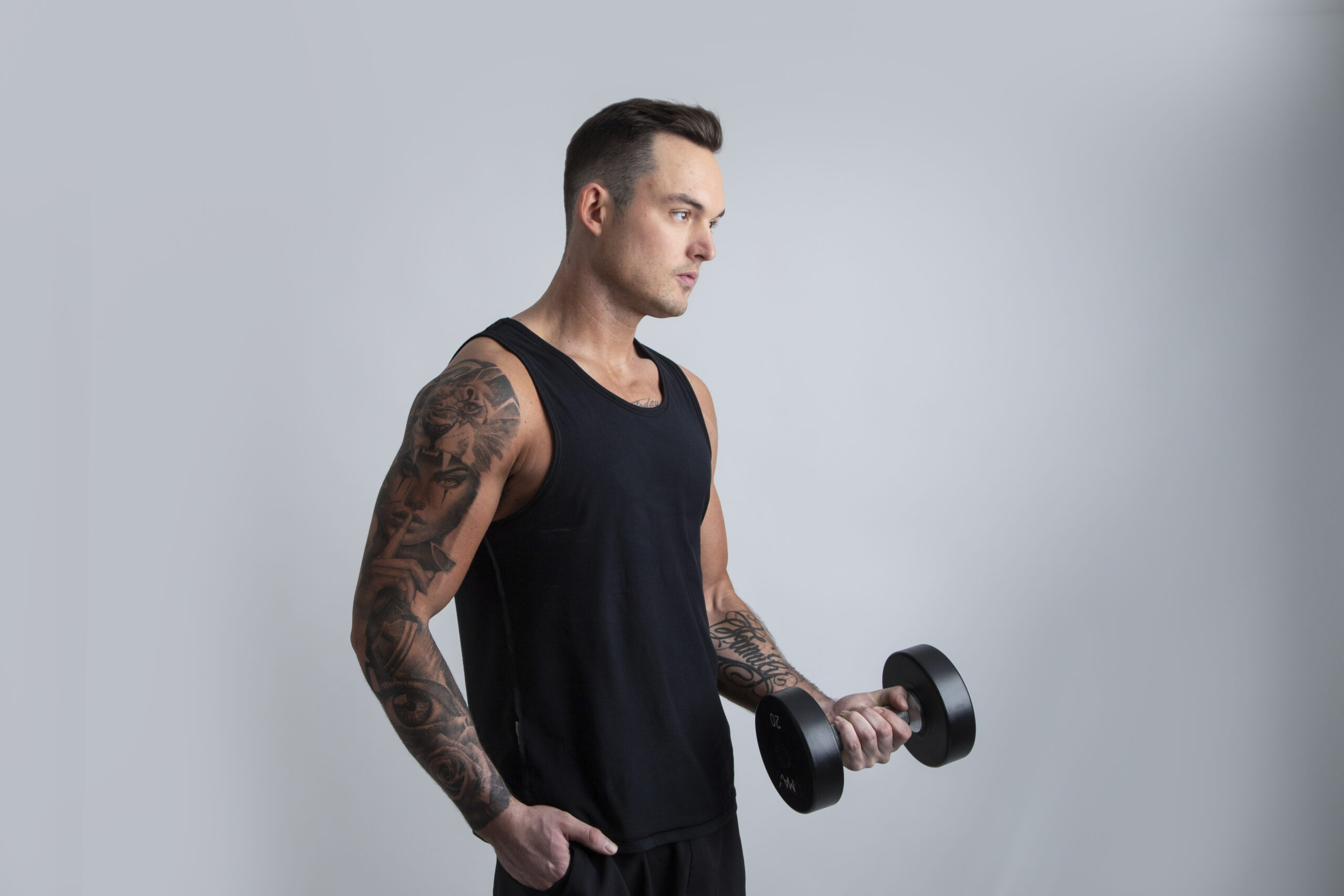 Professional fitness trainer flexing muscles with dumbell