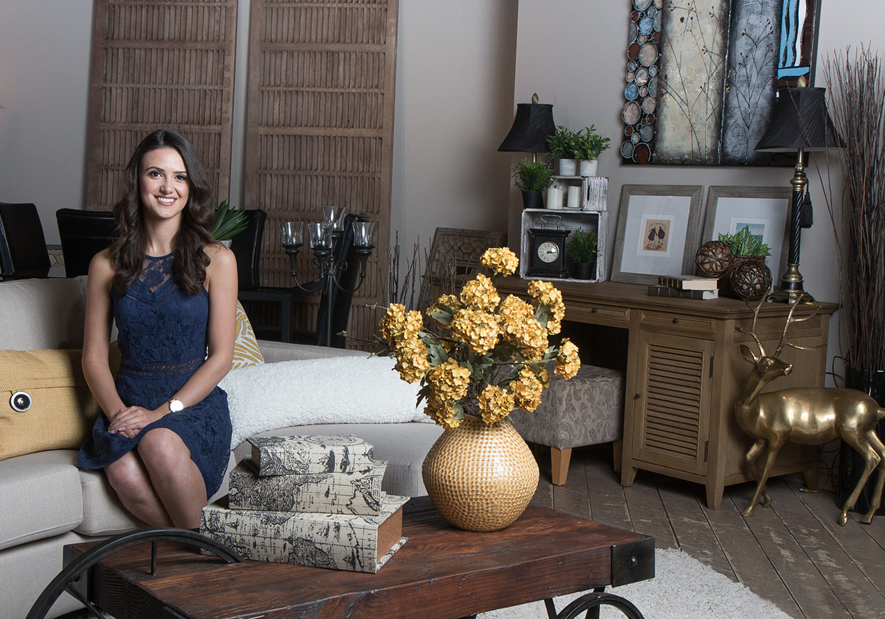 Beautiful woman at the consignment gallery in Calgary surrounded by luxury home items